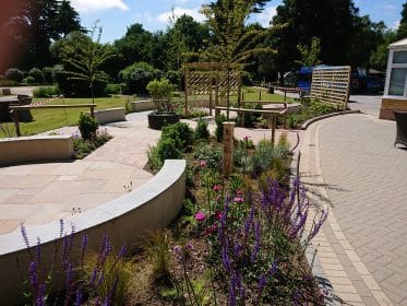 rendered wall, curved wall, sandstone paving, planting, granite, water feature, trellis, salvia, solar water feature