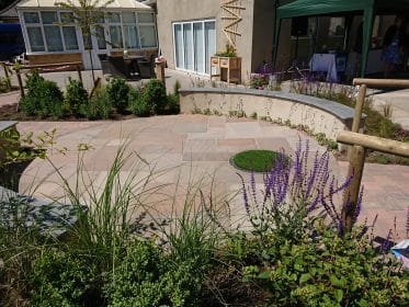 rendered wall, curved wall, sandstone paving, planting, granite, artificial grass