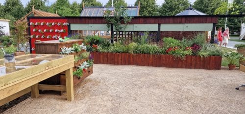 Raised bed and TV set in the RHS-BBC Morning Live Budget-friendly Feature Garden at RHS Hampton Court Palace Garden Festival 2023, designed by Mark Lane from Mark Lane Designs Ltd